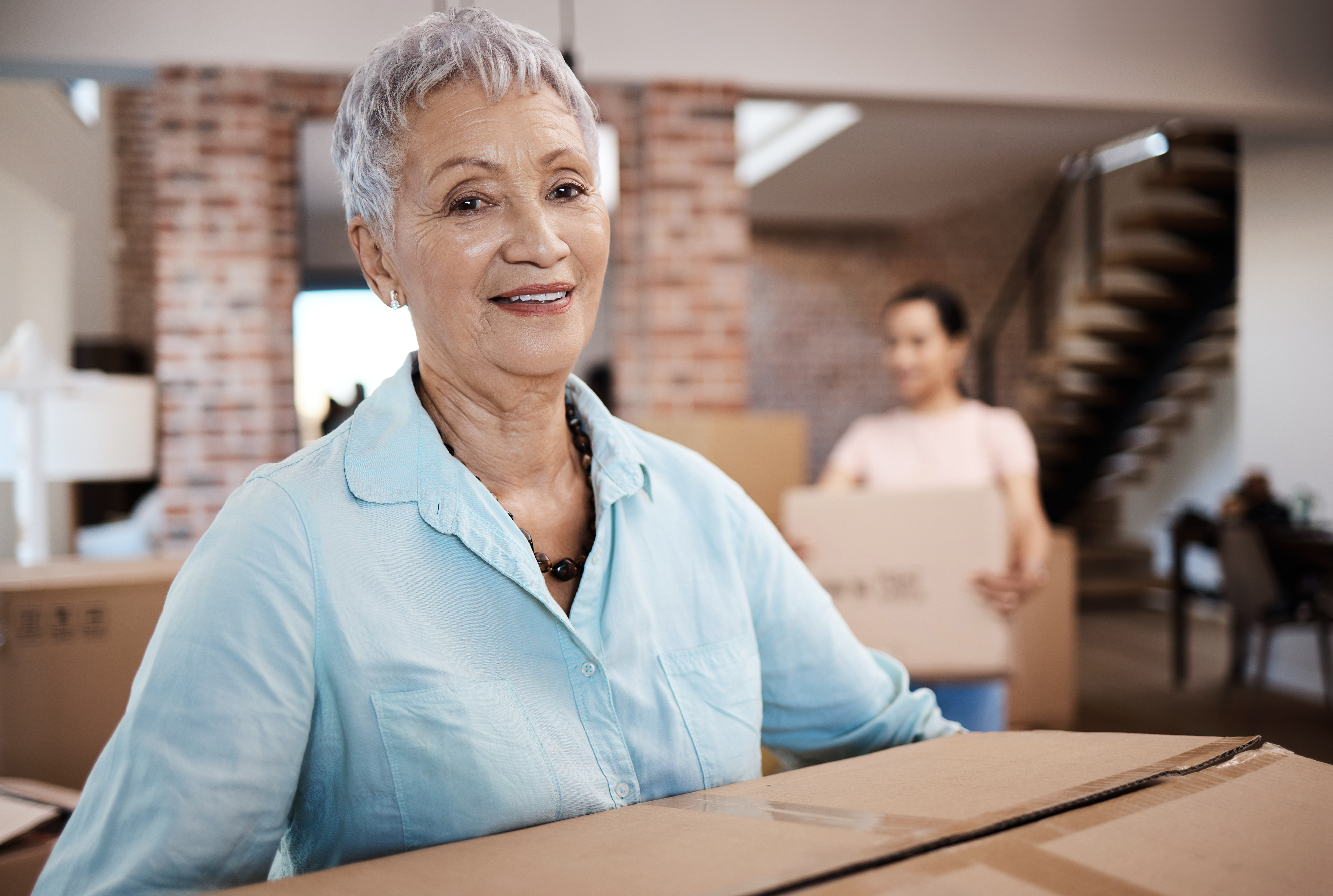 shot-of-a-senior-woman-moving-house-with-help-from-2022-09-27-15-37-57-utc (1)